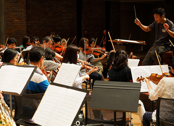 Person conducting orchestra using Manhasset stands